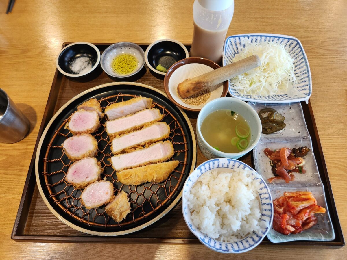 돈까스, 밥, 장국, 소스 등이 포함된 깔끔한 상차림 전경.