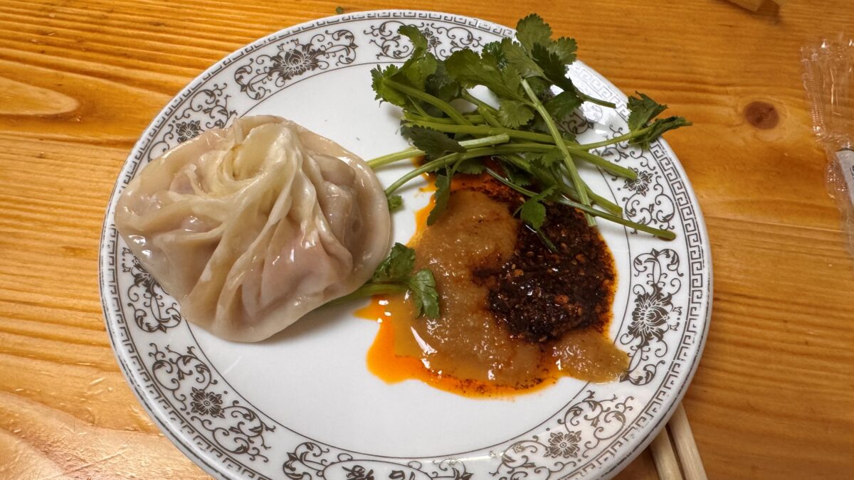 접시에 담긴 만두와 함께 곁들인 고수와 소스.