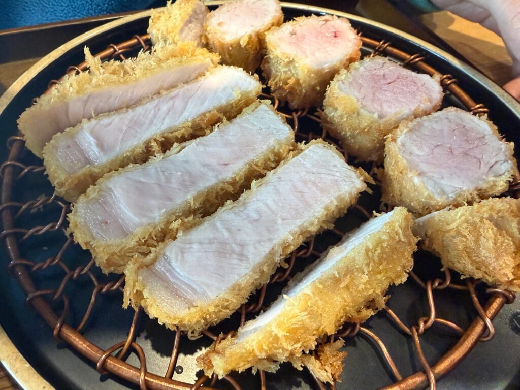 접시 위에 놓인 로스까스의 단면 근접 사진.