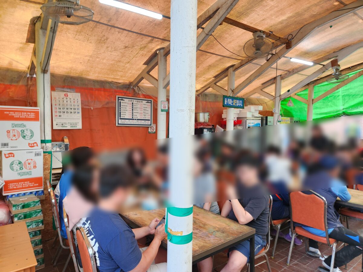식당 내부 천막 자리에 앉아 식사를 기다리는 손님들.