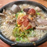 뚝배기에 담겨 끓고 있는 다대기가 올라간 순대국밥.