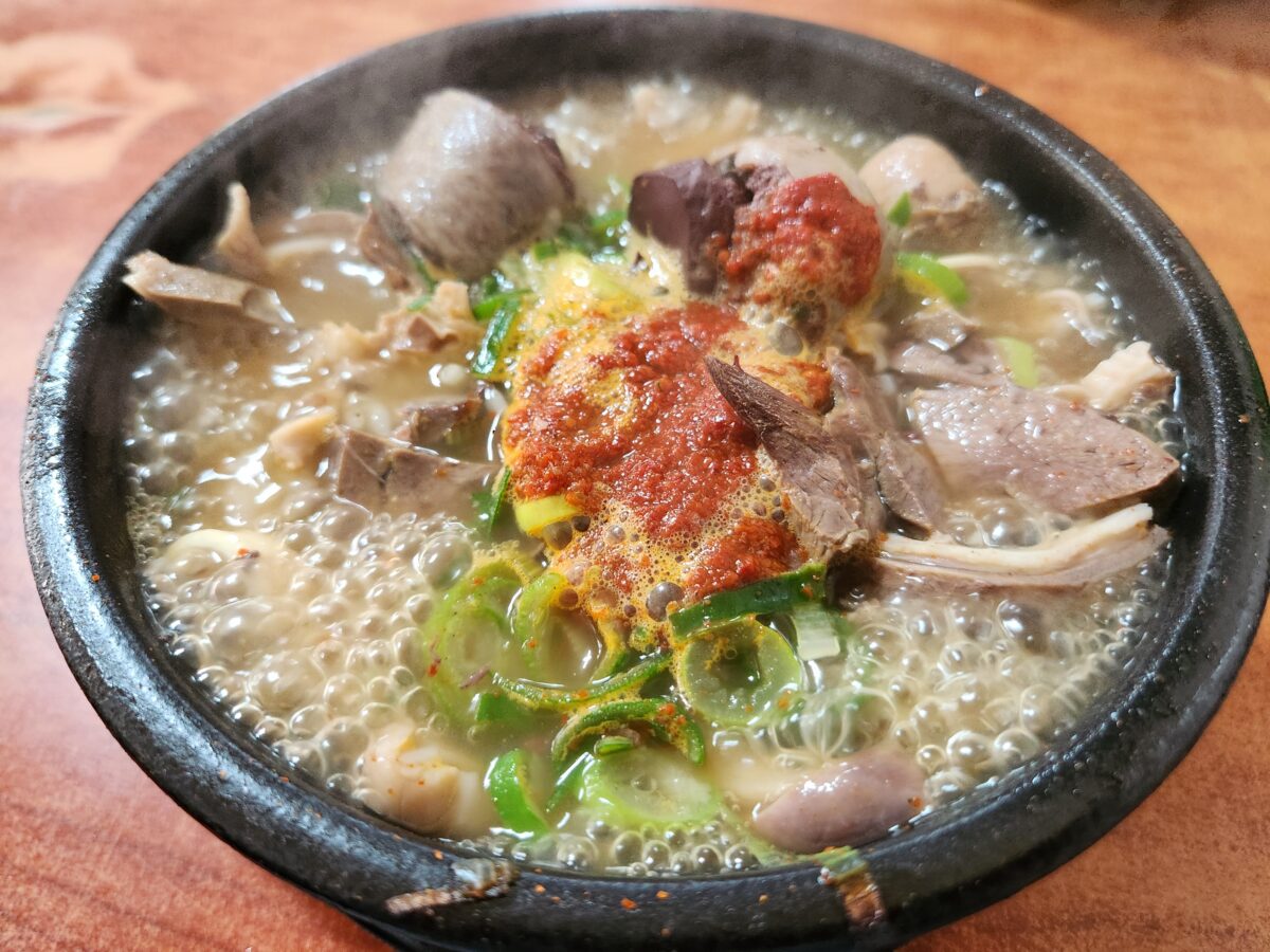 뚝배기에 담겨 끓고 있는 다대기가 올라간 순대국밥.