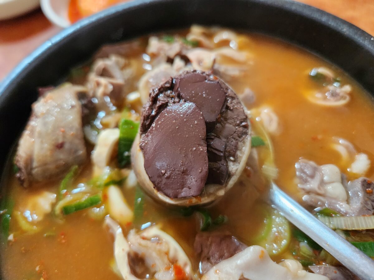 숟가락 위에 올려진 큼직한 선지 순대와 국밥 국물.
