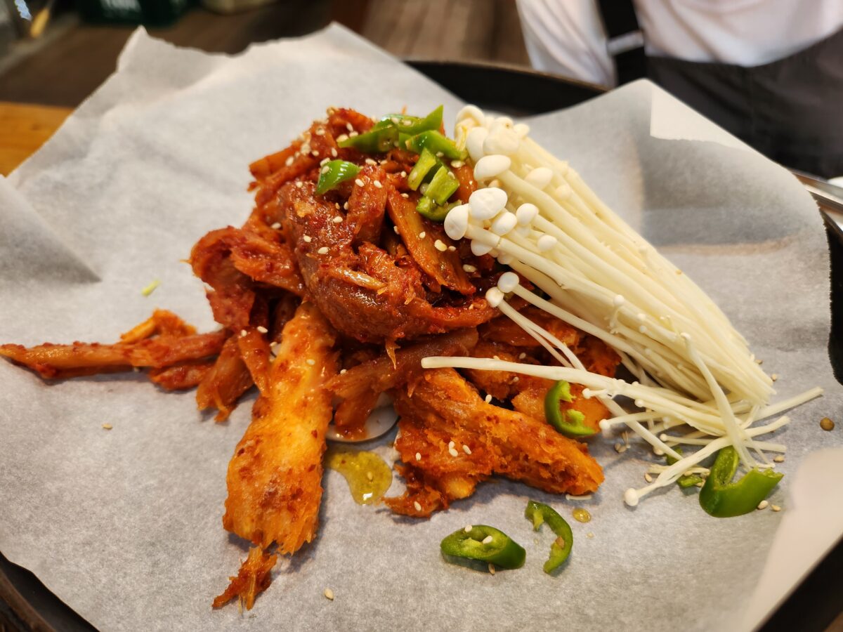 철판 위에 올라가기 전 접시에 담긴 더덕구이와 팽이버섯