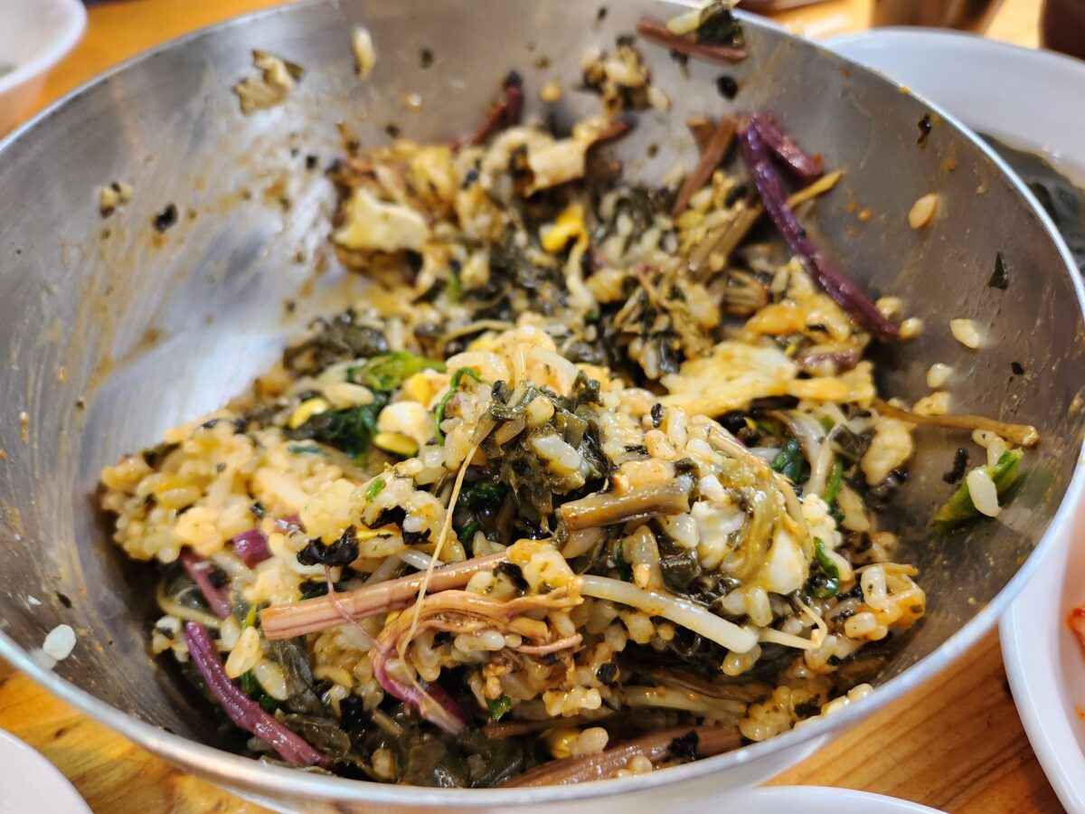 각종 나물이 듬뿍 담긴 대접에 비벼진 산채비빔밥