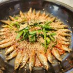 프라이팬에 담겨 깨가 뿌려진 도리뱅뱅이 근접 촬영.