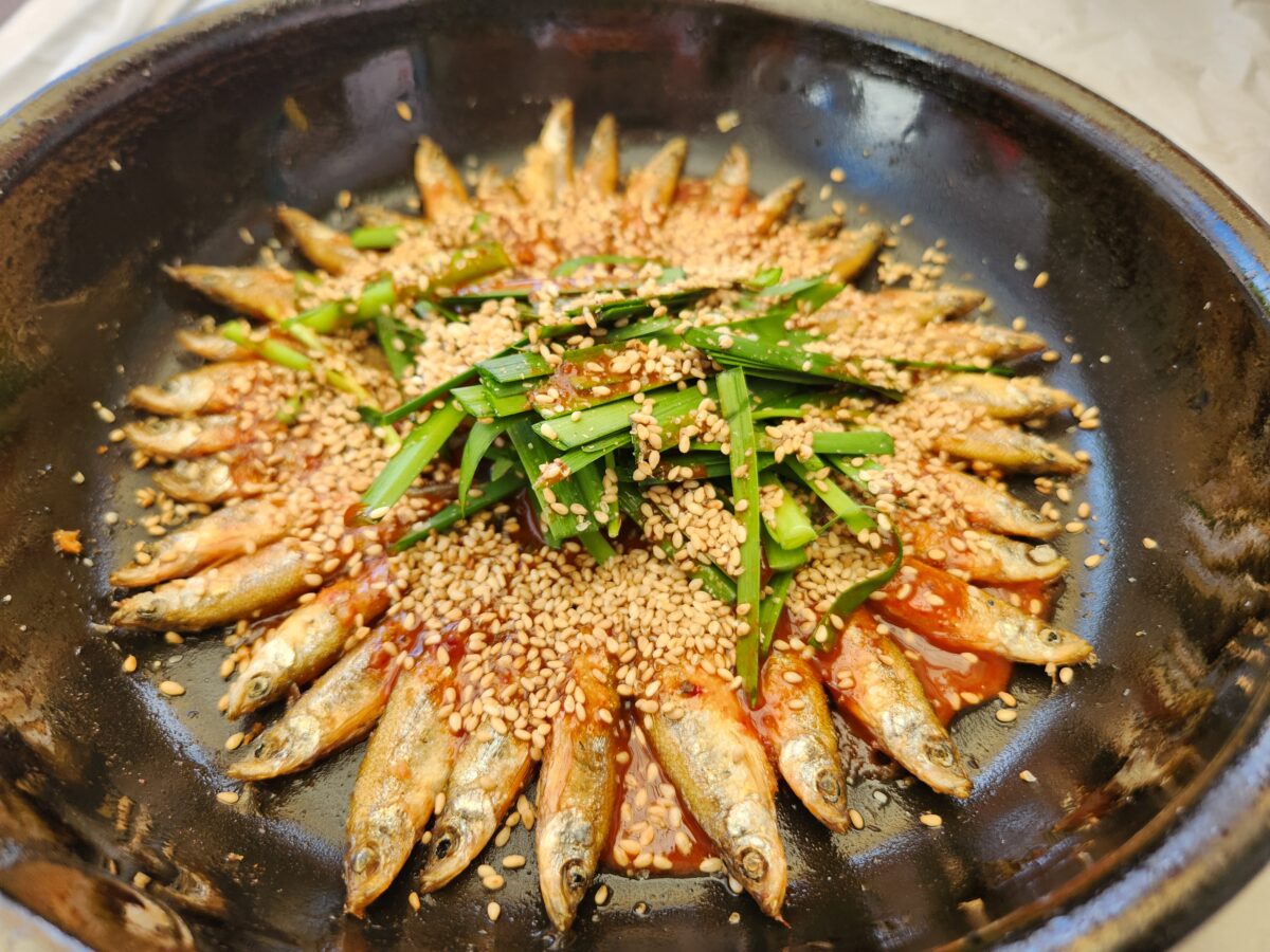 프라이팬에 담겨 깨가 뿌려진 도리뱅뱅이 근접 촬영.