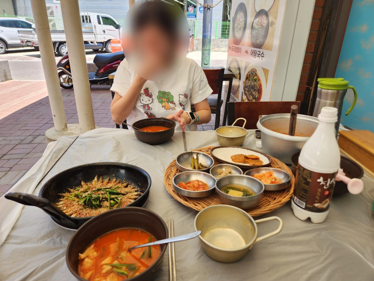 테이블 위에 차려진 도리뱅뱅이와 어탕 수제비, 막걸리 병.