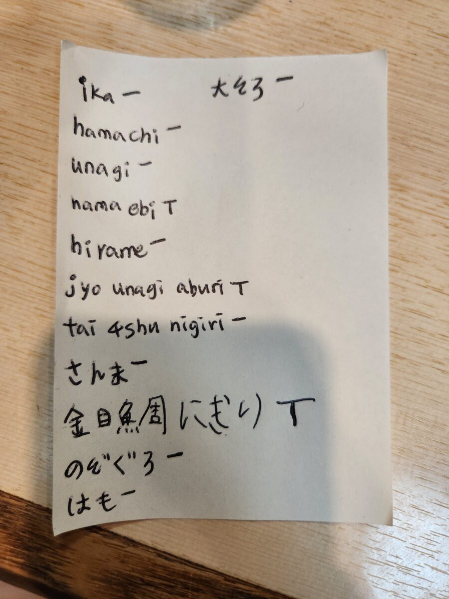 손글씨로 다양한 초밥 이름이 적힌 주문서