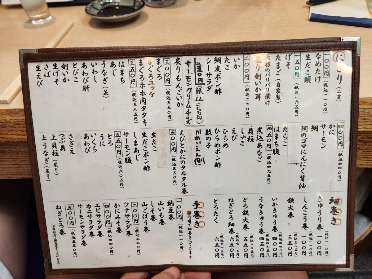 하루코마 지점의 초밥 및 요리 메뉴가 적힌 종이 메뉴판