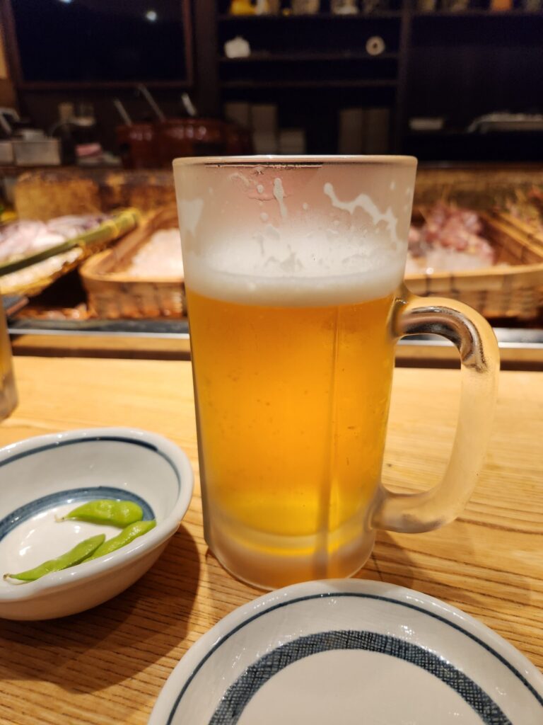 맥주잔이 강조된 로바다야끼 내부 테이블 전경.