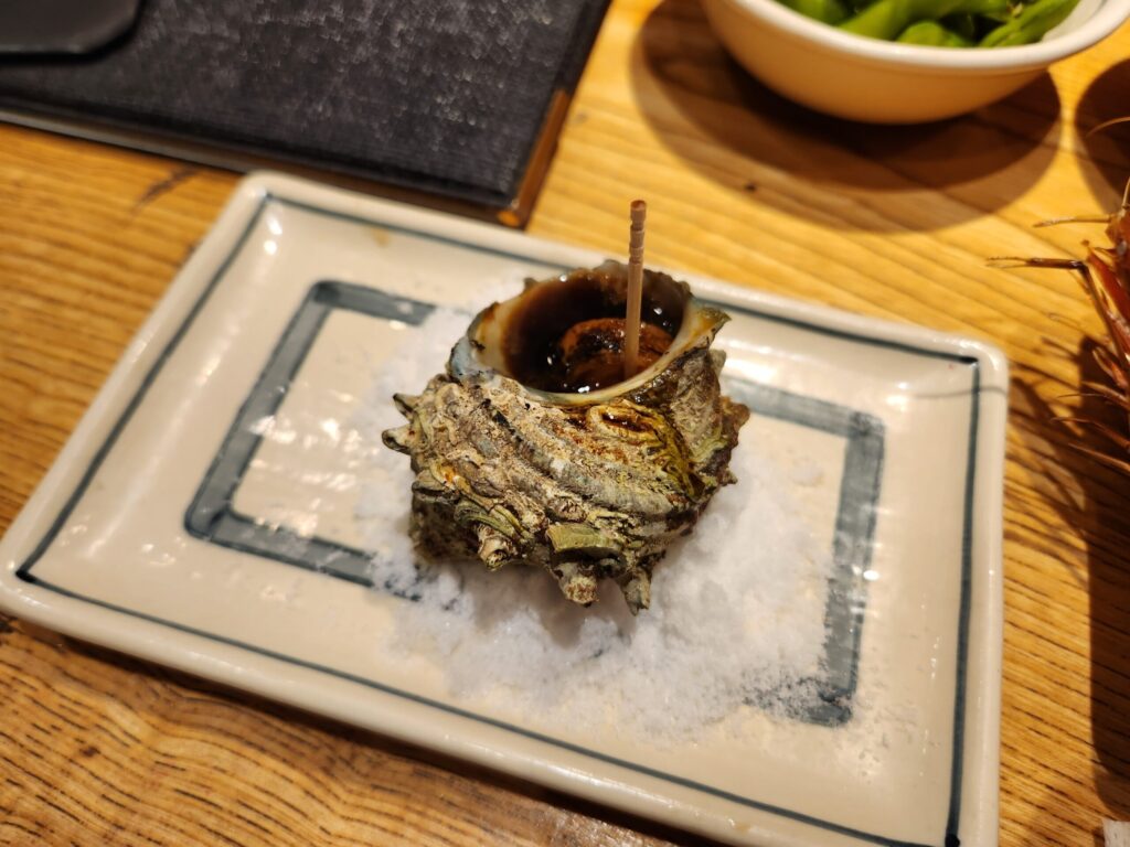 소금 위에 올려진 뿔소라 구이.