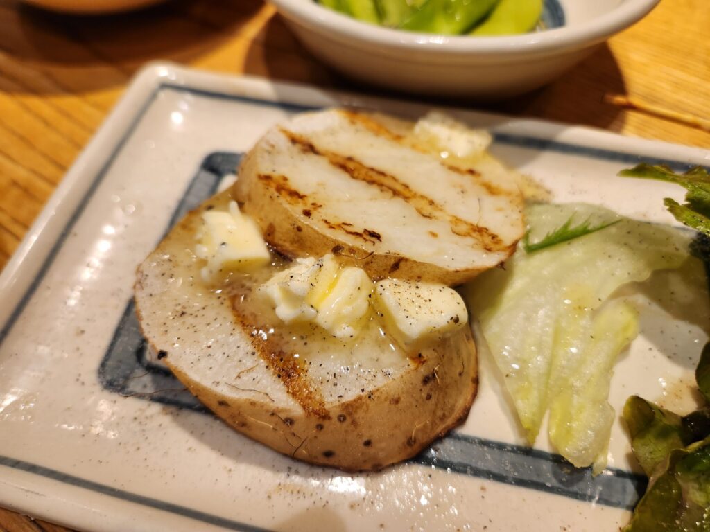 버터 조각이 올라간 구운 감자 슬라이스.