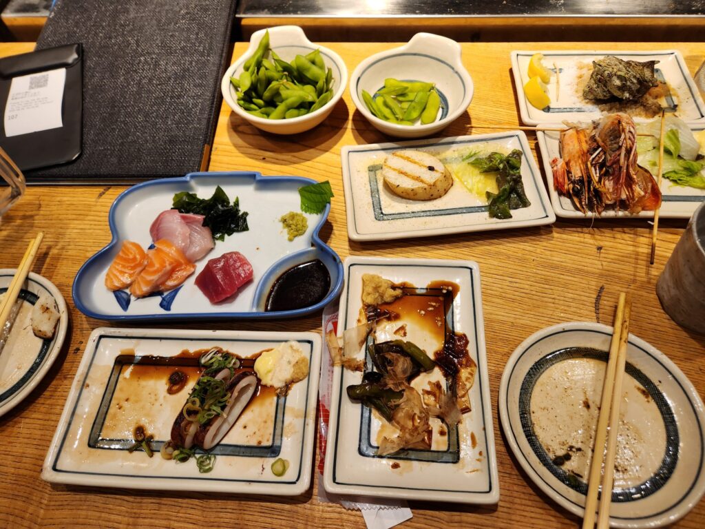 회, 구이, 샐러드 등 다양한 안주가 차려진 테이블.