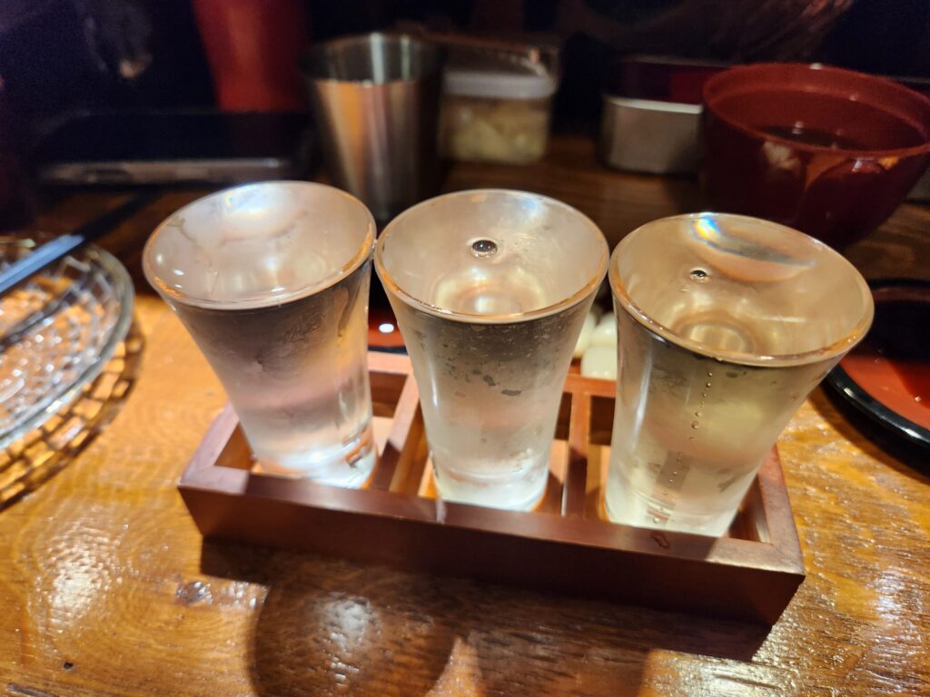 나무 트레이에 담긴 세 잔의 사케 샘플.