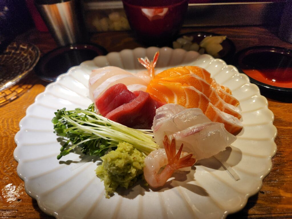 접시에 담긴 단새우, 광어, 참치, 연어, 참돔 등 모듬회와 무순, 와사비 세팅.