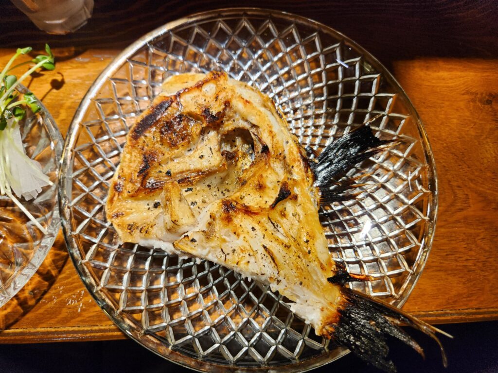 유리 접시에 담긴 노릇하게 구워진 생선구이.