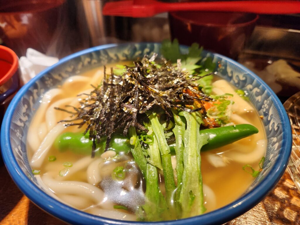김가루가 뿌려진 얼큰한 국물의 우동 그릇.