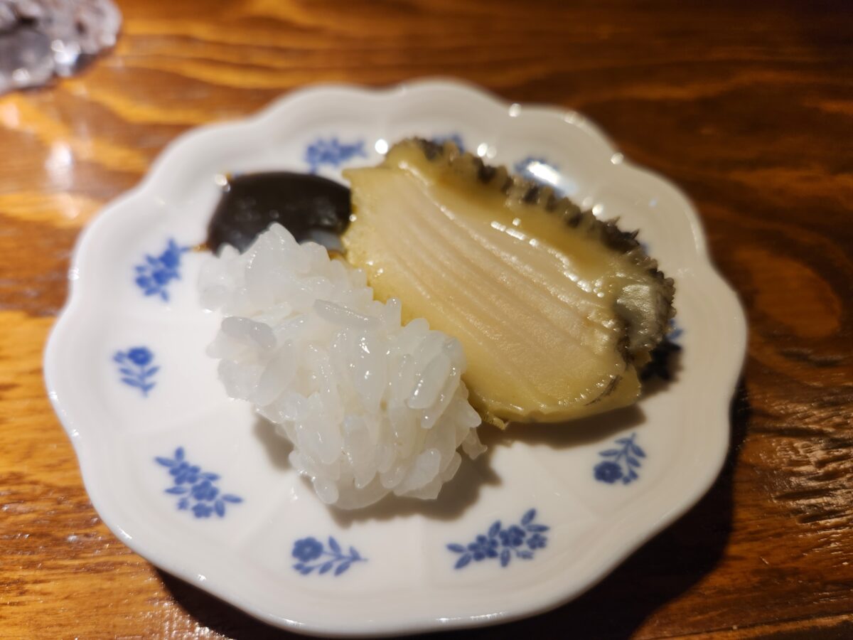 접시에 담긴 전복찜과 밥, 그리고 내장소스.