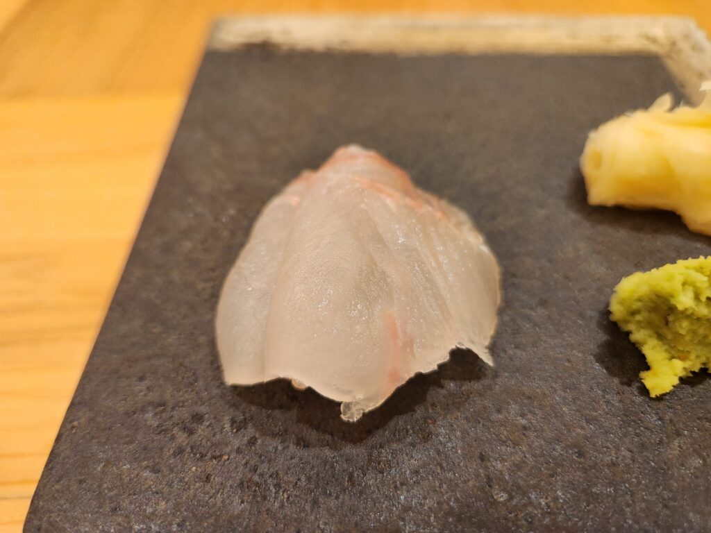 검은 돌판 위에 올려진 광어 초밥
