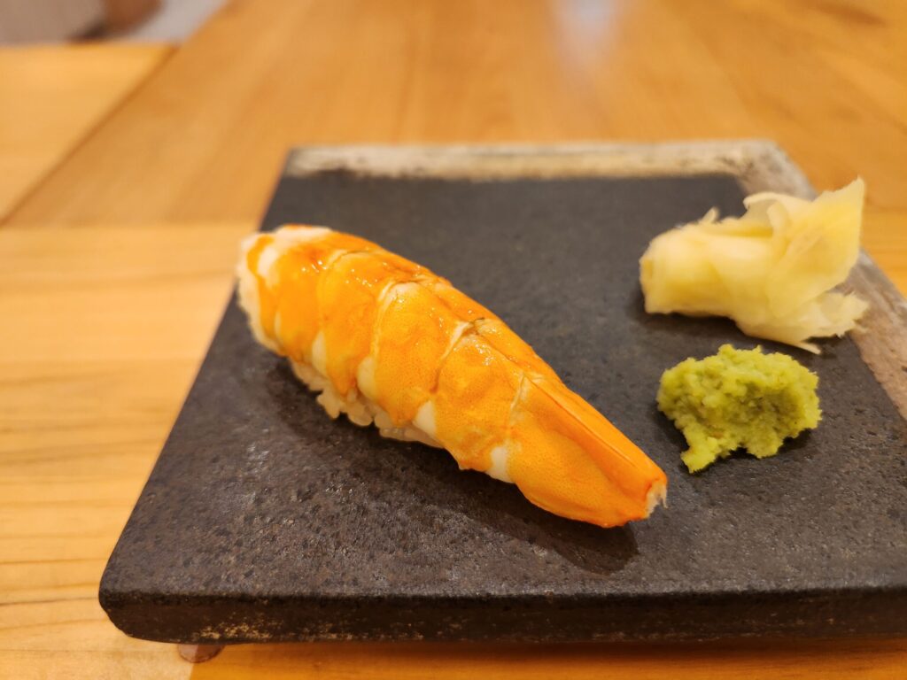 검은색 돌판 위에 올려진 새우 초밥