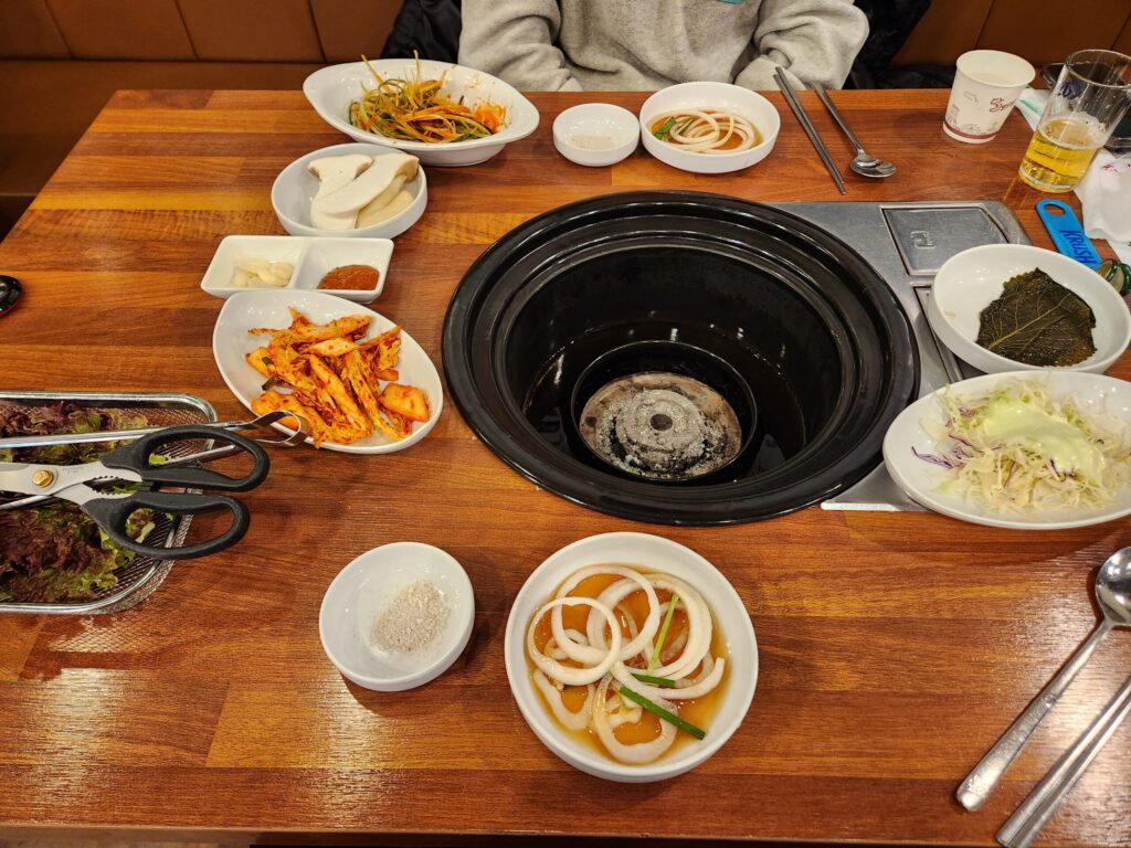 기본 반찬과 빈 불판이 세팅된 테이블 전체 샷.