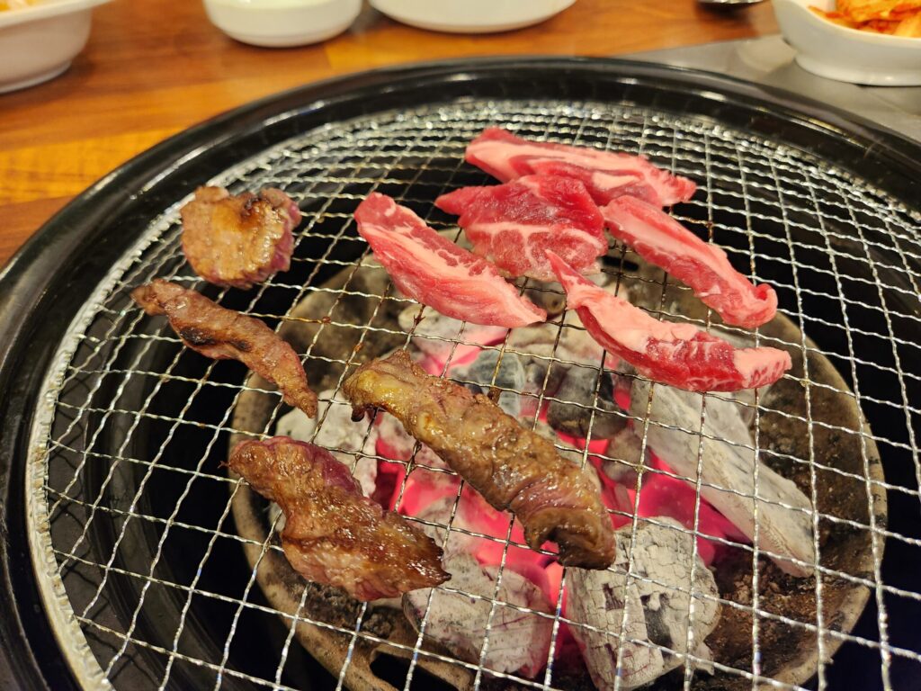 숯불 위에서 고기가 구워지고 있는 모습.