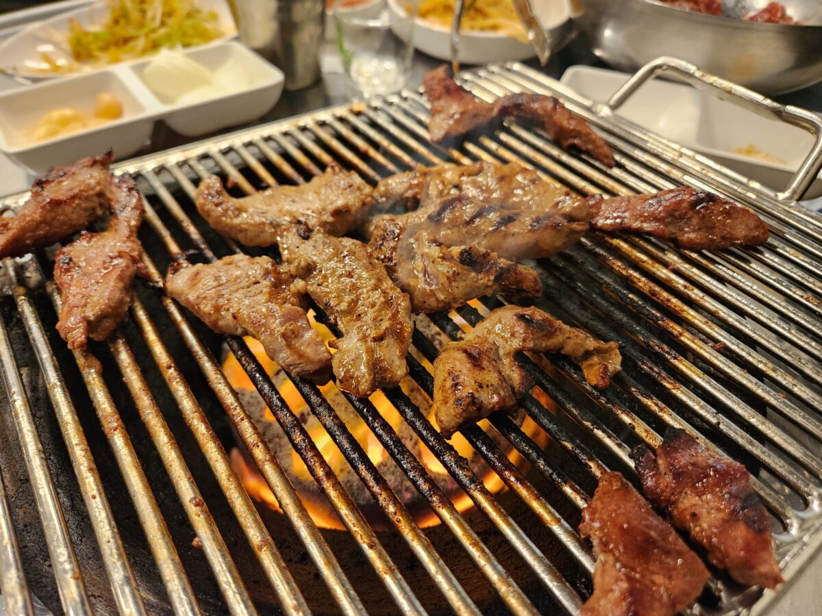 연탄불 석쇠 위에서 맛있게 구워지고 있는 갈매기살 근접 촬영 사진