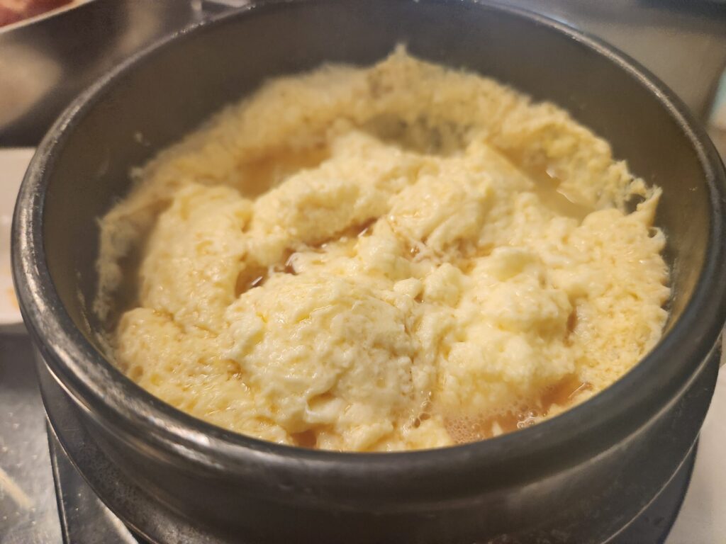 뚝배기에 담겨 보글보글 끓고 있는 따뜻한 계란찜의 모습