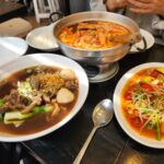 쌀국수, 똠양꿍, 쏨땀이 차려진 테이블 항공 샷.