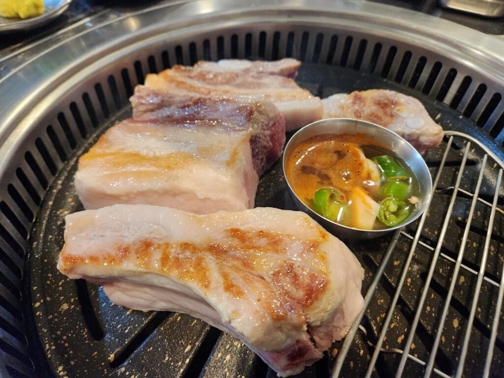 불판 위에서 고기가 구워지는 모습.