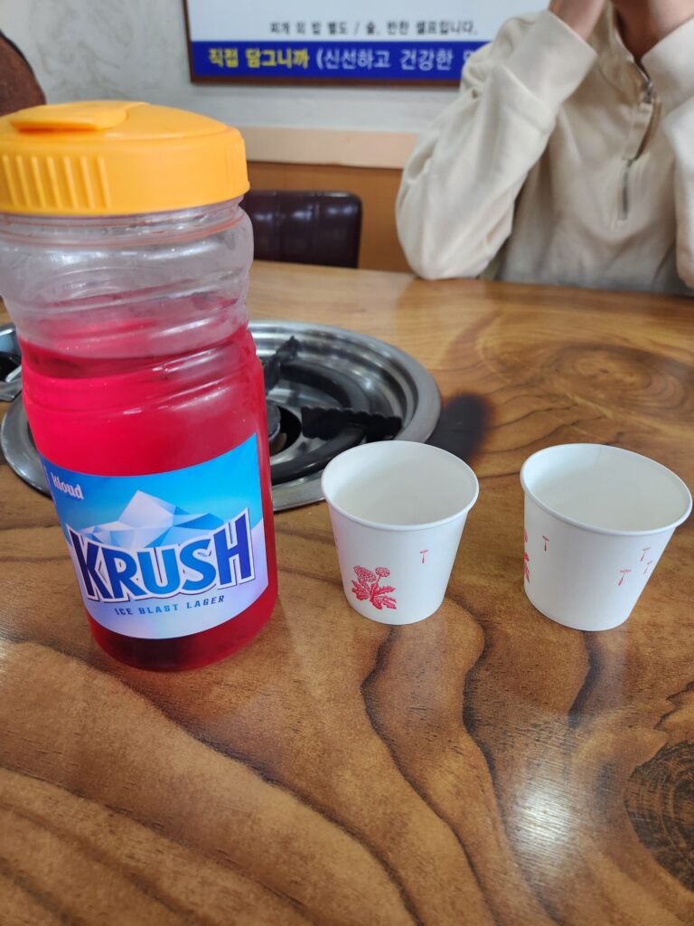 비트가 우러나 붉은색을 띠는 물이 담긴 컵과 물병.