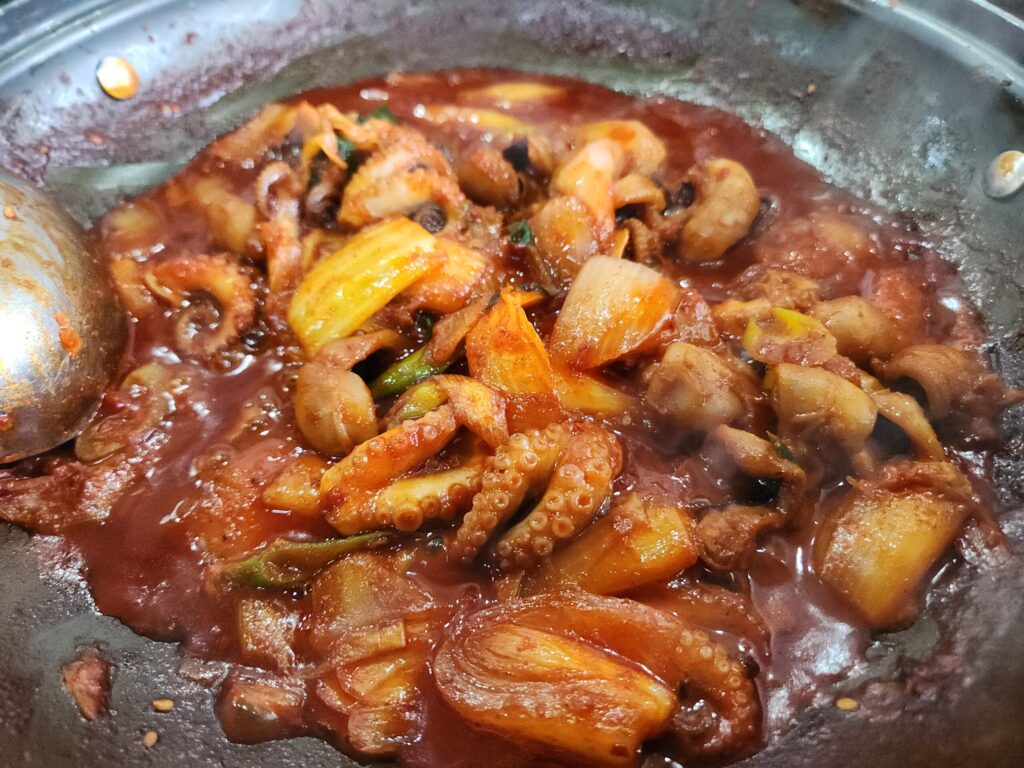 팬 위에서 맛있게 볶아지고 있는 쭈꾸미 볶음 요리.