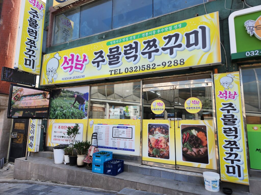 석남주물럭쭈꾸미 식당의 노란색 간판이 보이는 매장 입구 전경