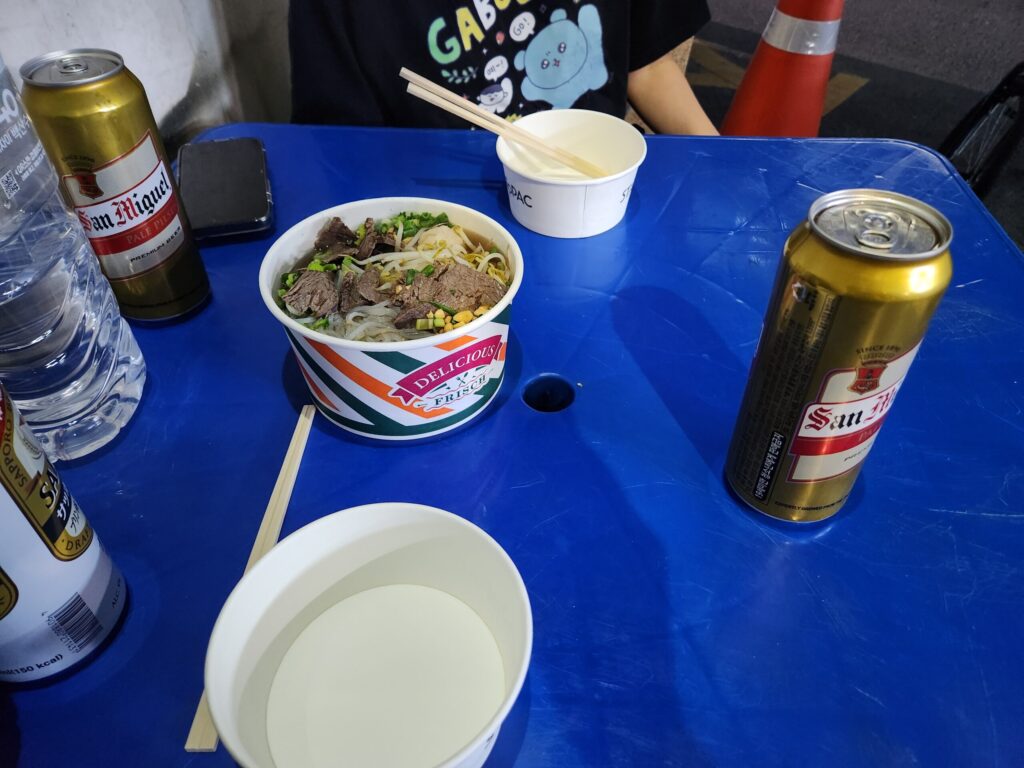 테이블 위에 놓인 태국 쌀국수와 맥주 캔들