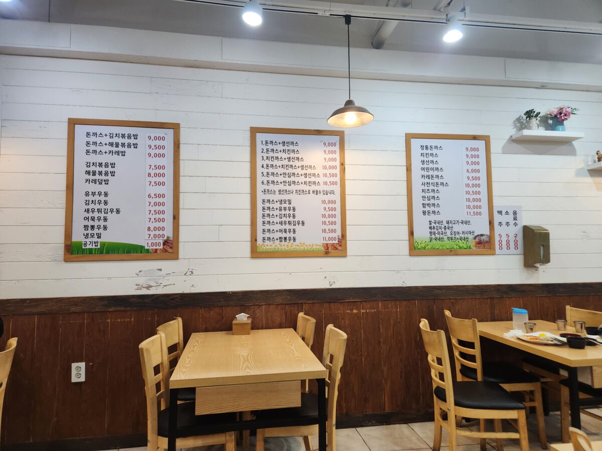 가게 내부 벽면에 붙은 메뉴판과 식당 내부 모습.
