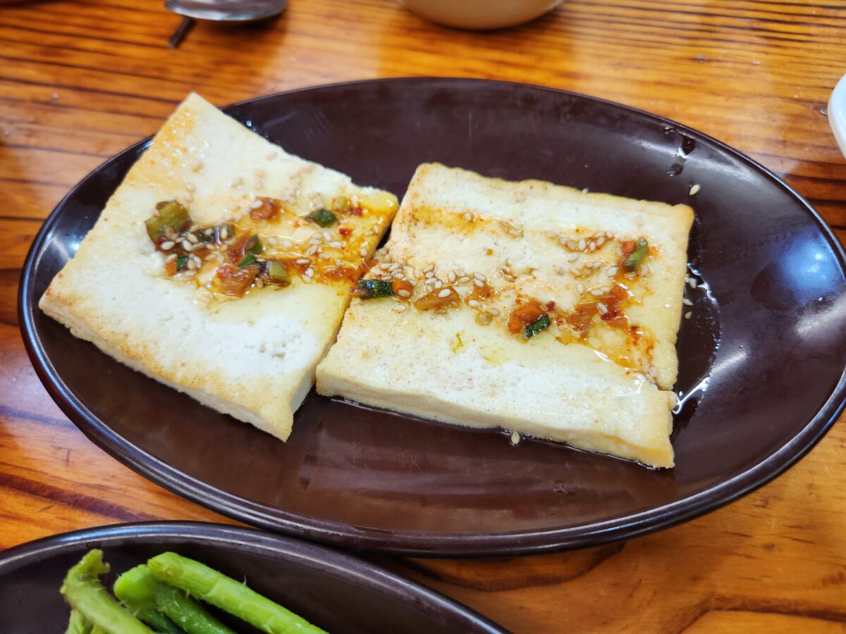 양념장이 올라간 두부지짐 근접 사진.