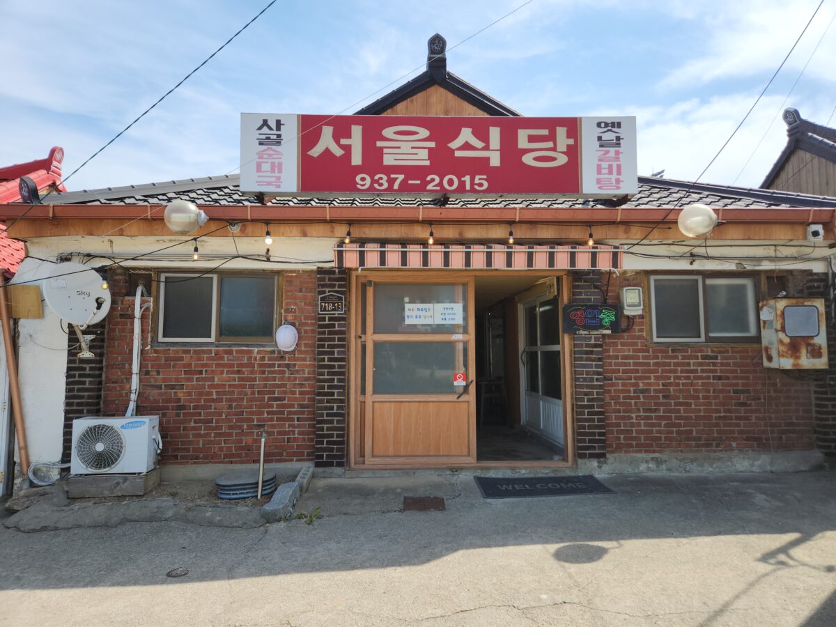 빨간 간판이 달린 벽돌 건물 서울식당의 외부 전경