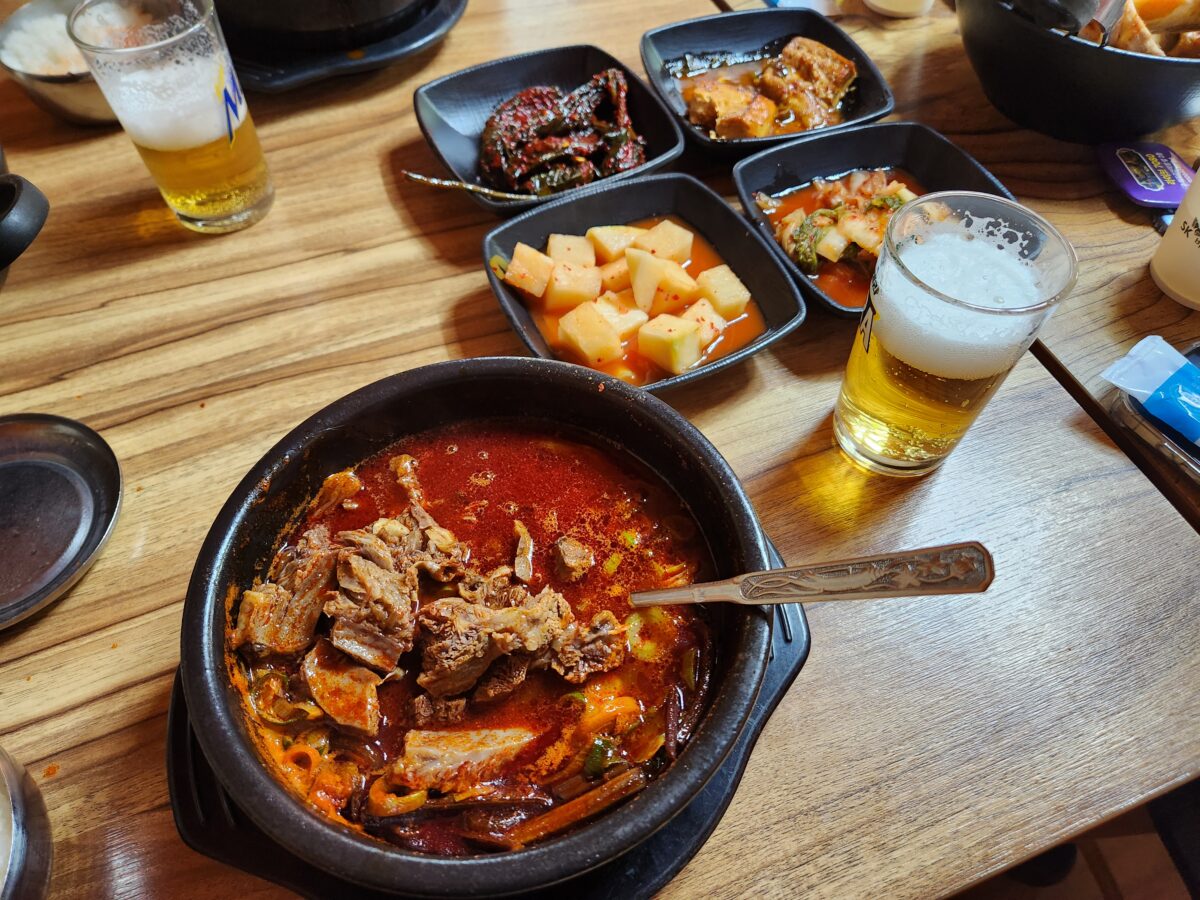 육갈탕과 맥주잔이 함께 놓인 테이블 상차림