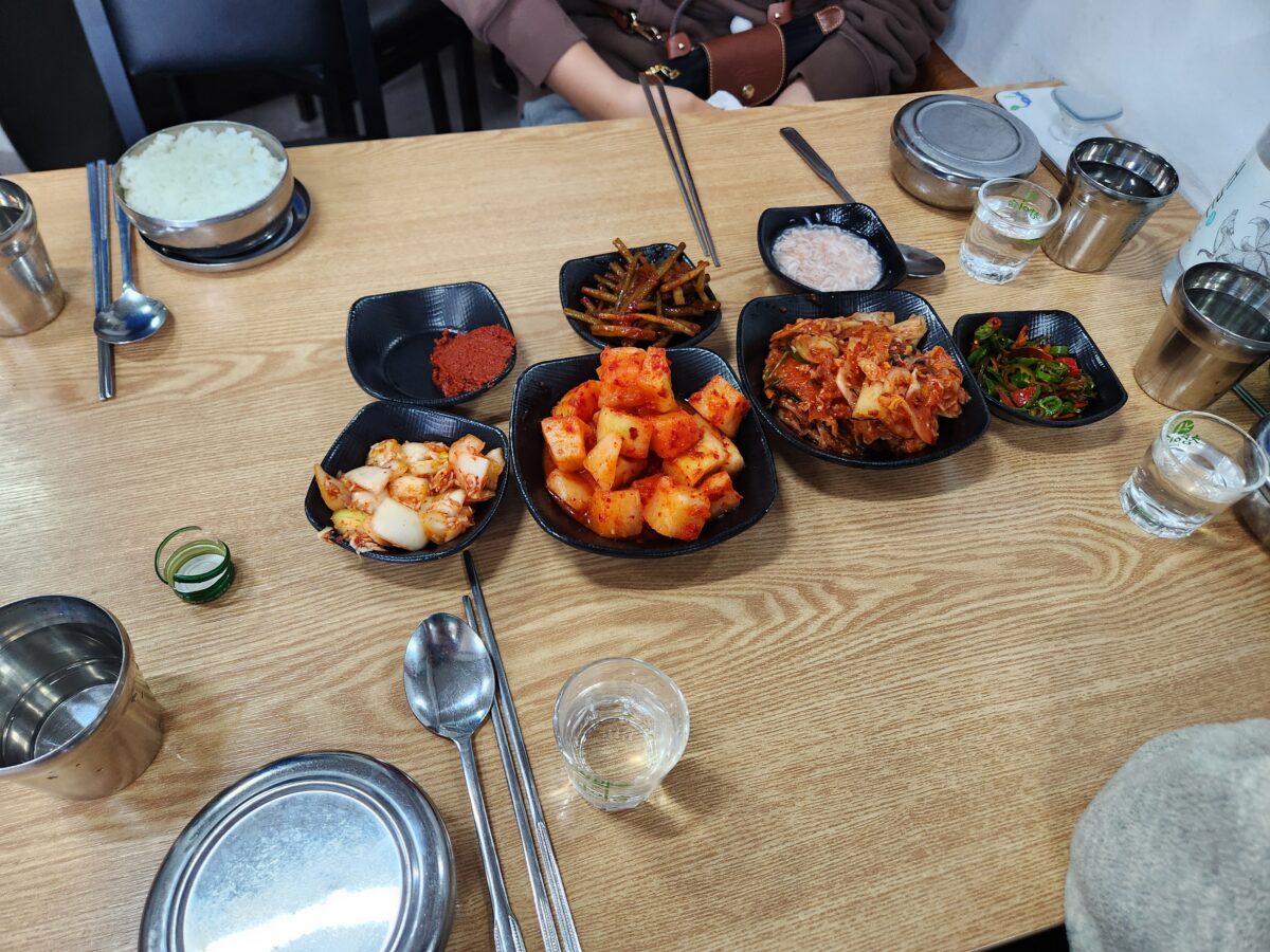 순대국이 나오기 전 테이블에 세팅된 김치, 마늘쫑, 다데기 등 기본 상차림 모습