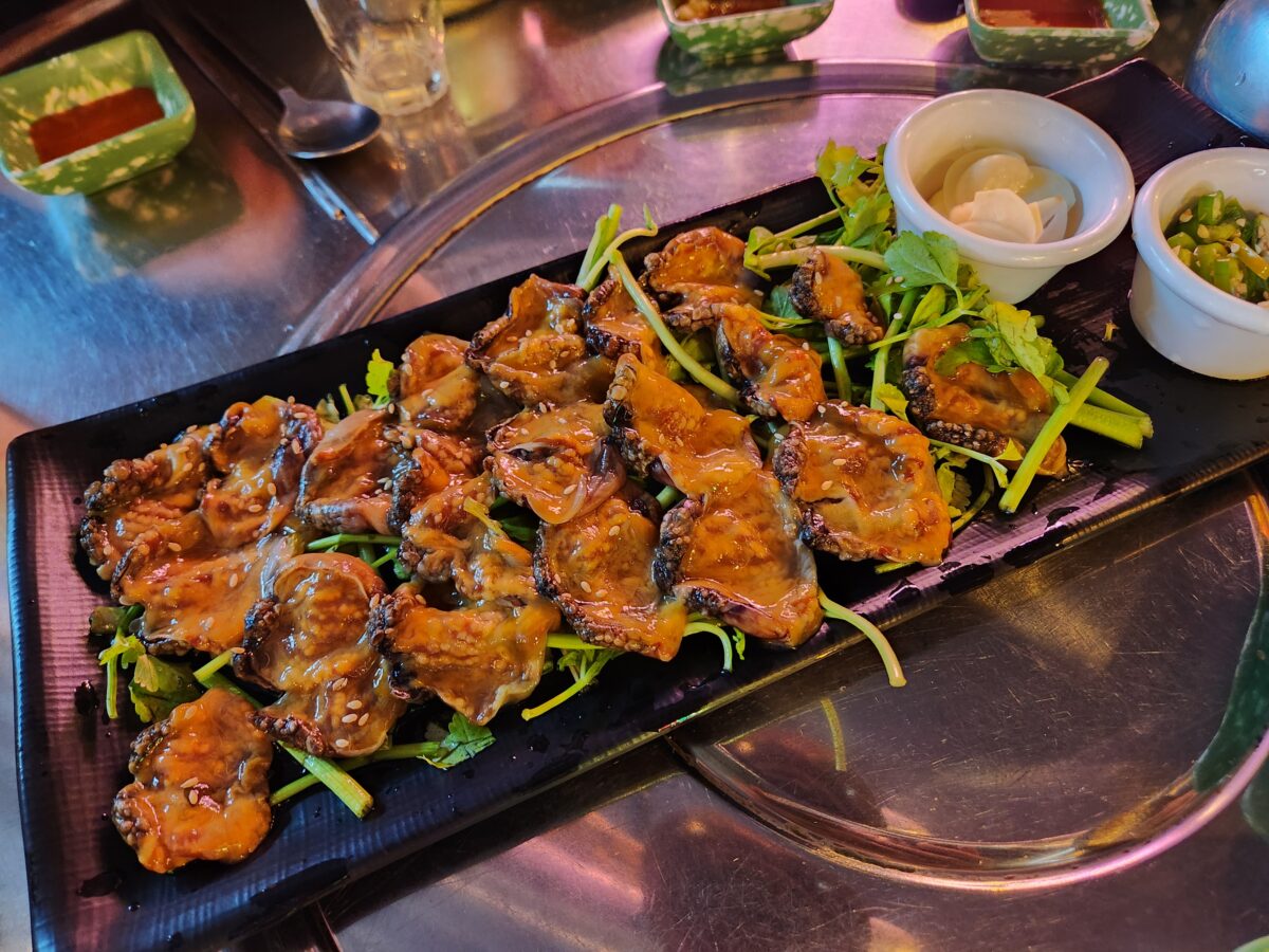 검은 접시에 정갈하게 담겨 나온 신선한 미더덕회 근접 샷.