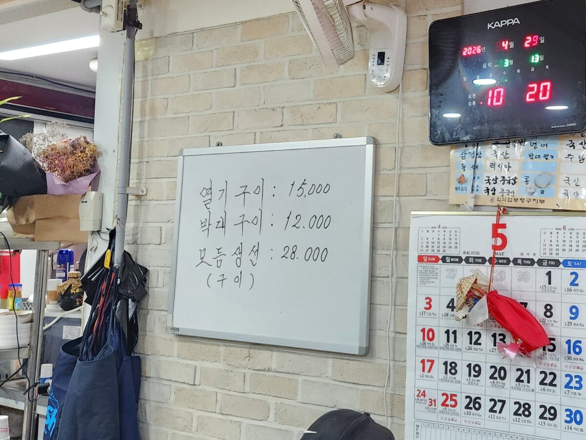 생선구이 메뉴가 적힌 종이 메뉴판과 달력이 붙은 벽면.