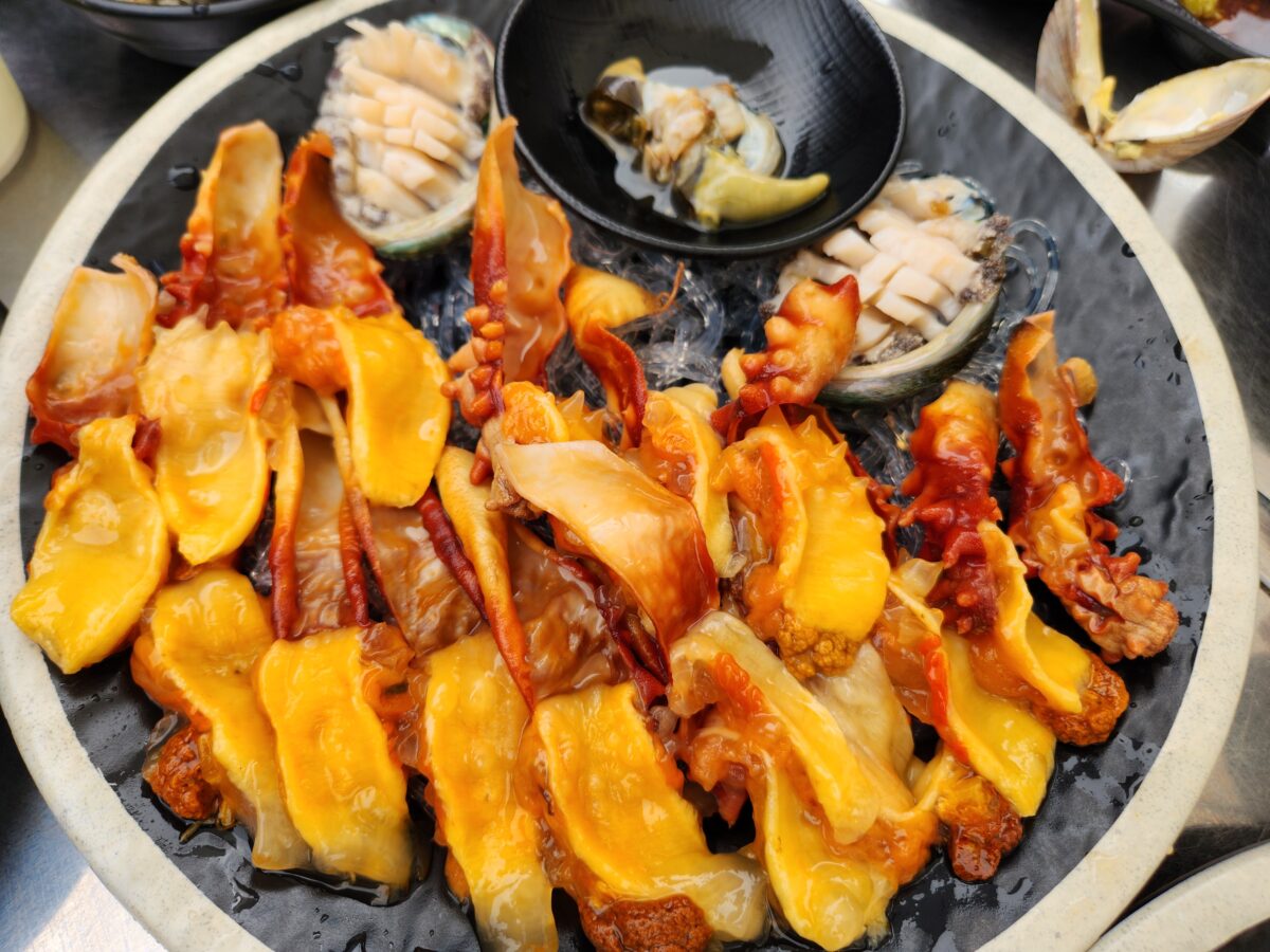 검은 접시에 담긴 주황빛의 신선한 멍게.
