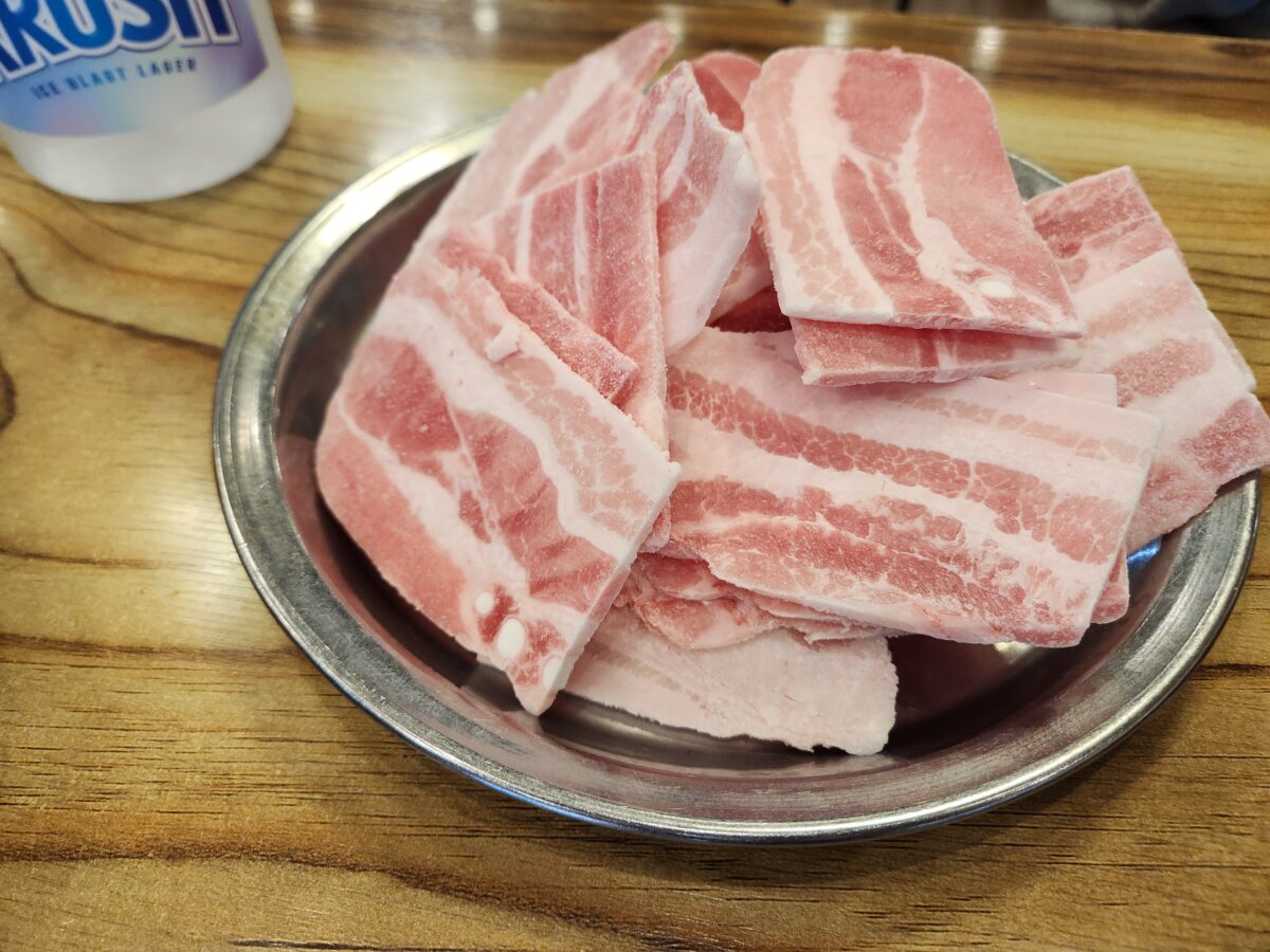 접시에 담긴 생 냉동 삼겹살 2인분.