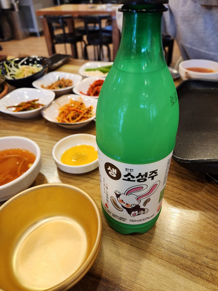 테이블 위에 놓인 인천 소성주 막걸리 병과 빈 막걸리 잔.