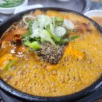 팔팔 끓고 있는 뼈해장국 뚝배기 근접 사진.