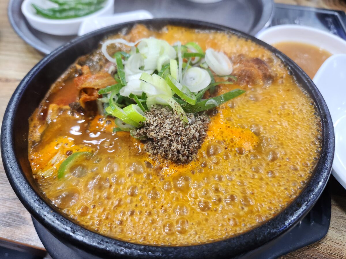 팔팔 끓고 있는 뼈해장국 뚝배기 근접 사진.