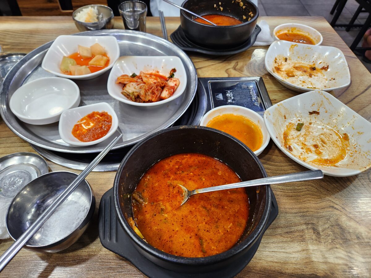 뼈해장국을 다 먹고 난 후의 빈 그릇과 기본 찬들이 놓여있는 테이블 모습.