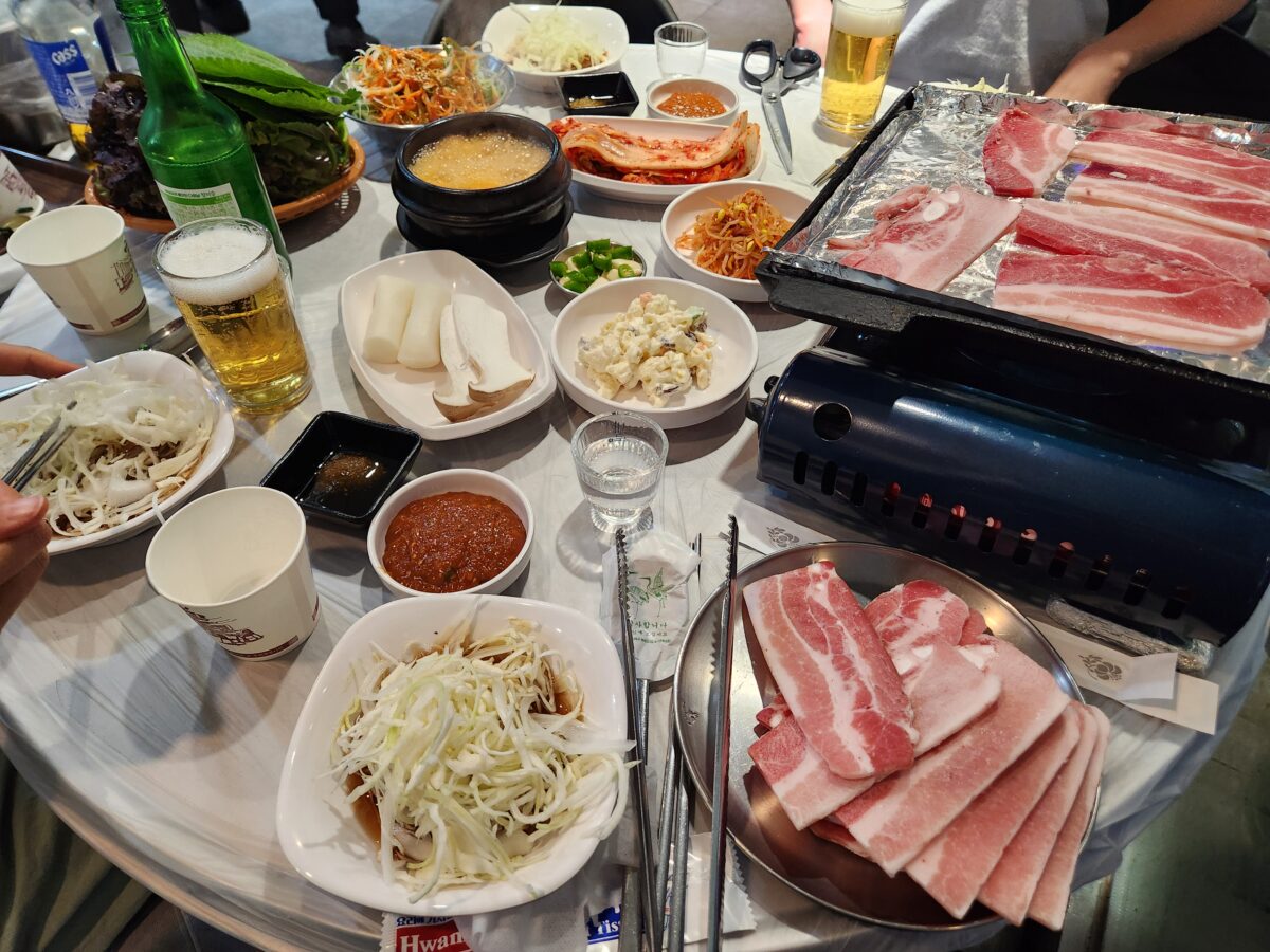 냉삼겹살과 각종 밑반찬이 차려진 테이블 전체 샷