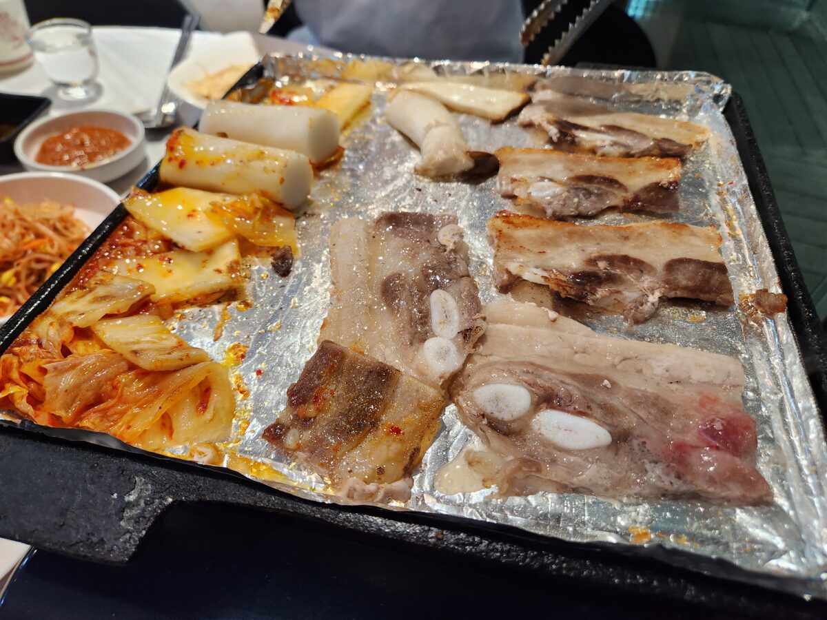 불판 위에서 구워지는 냉삼겹살과 가래떡, 버섯